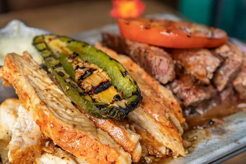 Grilled fajita meats with charred peppers and tomato