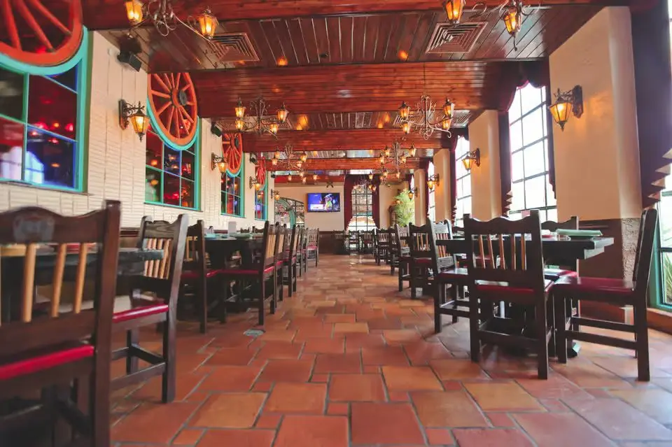 Dining room at El Tiempo Gessner with wooden ceiling and saltillo tile floors